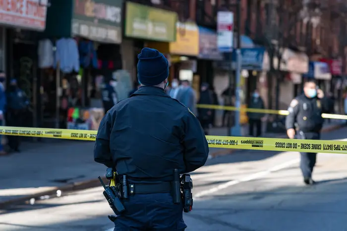 NYPD sections off the scene of a shooting where shots were fired from a car that was driving on the Lower East Side on February 16th. A 57 year old woman who was an innocent bystander was struck in the buttocks.